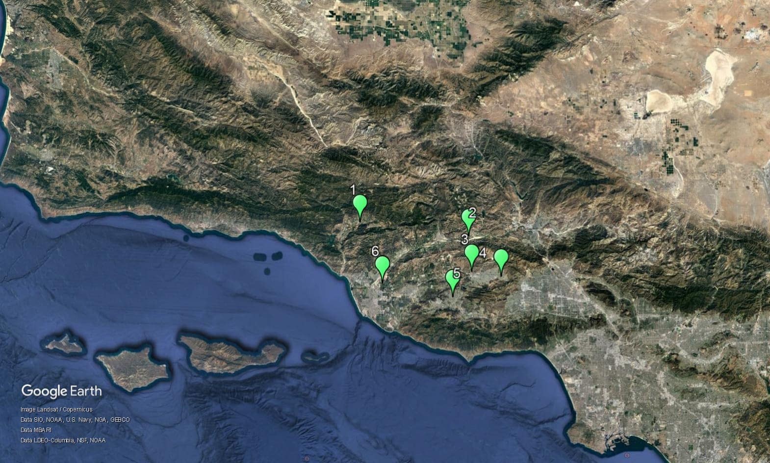 A satellite view map showing a coastal region with six numbered green map pins placed in mountainous and urban areas.